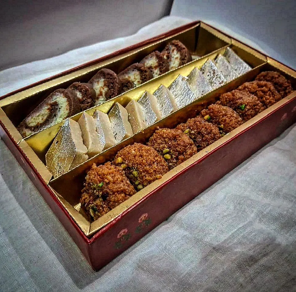 An assortment of traditional Indian sweets arranged in a gift box