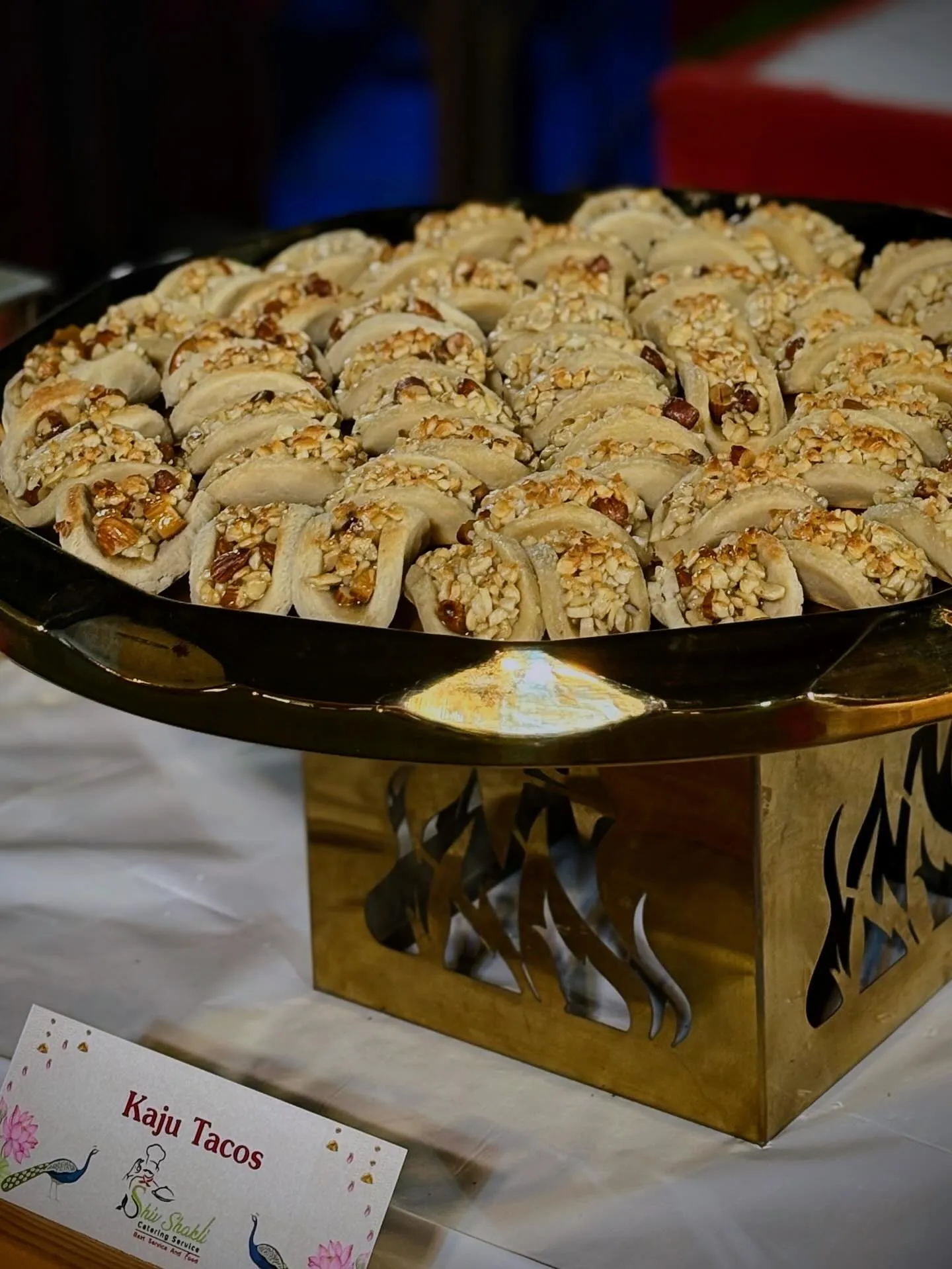 A tray of kaju taco sweets labelled for a dessert counter
