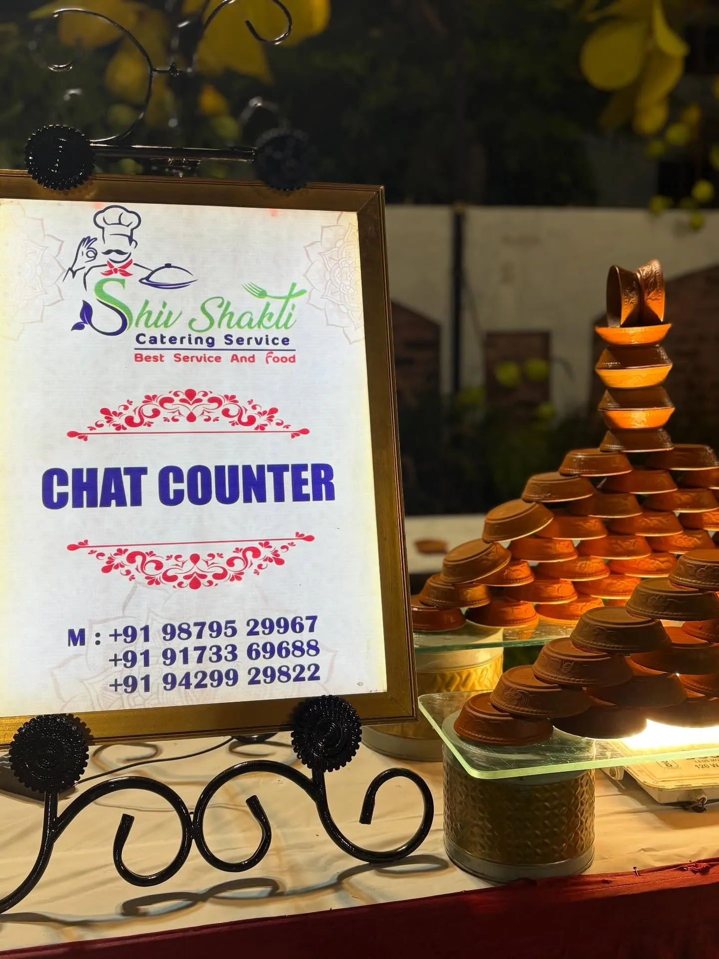 Branded chaat counter signage beside stacked terracotta serving bowls